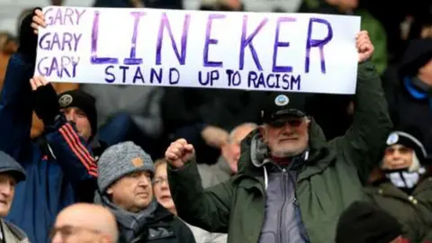 Reuters Fans at Swansea City ground holding up placard in support of Gary Lineker