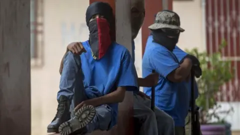 EPA Men with covered faces guard a square in Masaya, Nicaragua, 18 July 2018, one day after the so-called "Operation Cleaning". T