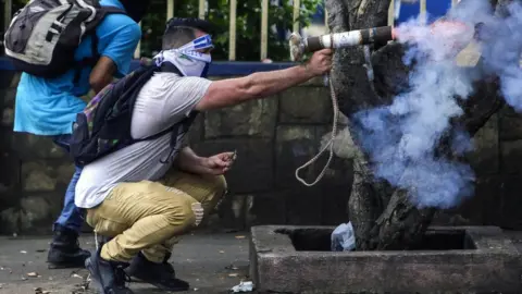 AFP A protester fires a homemade mortar during clashes with riot police. The small welded tubes are hand-held