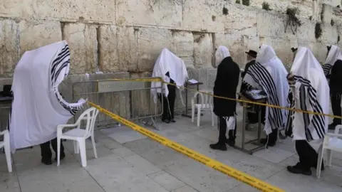 AFP People pray take precautions against the coronavirus while praying at the Western Wall in Jerusalem’s Old City (23 March 2020) AFP