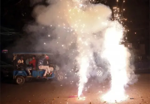 Reuters Men travel in a trishaw as firecrackers burn on a street during Diwali, the Hindu festival of lights, in New Delhi, India, November 7, 2018