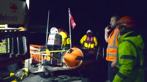 RNLI Volunteer crews on a lifeboat in hi-vis jackets