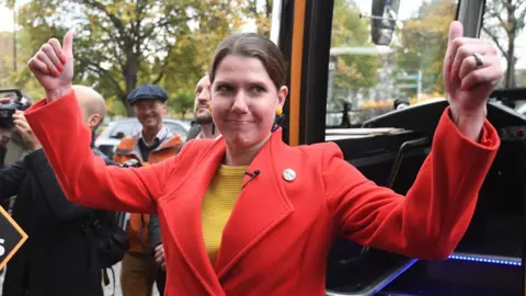 EPA Liberal Democrat leader Jo Swinson greets supporters as she arrives on the battle bus during a campaign visit to cafe Amisha in South Bermondsey in London, Britain