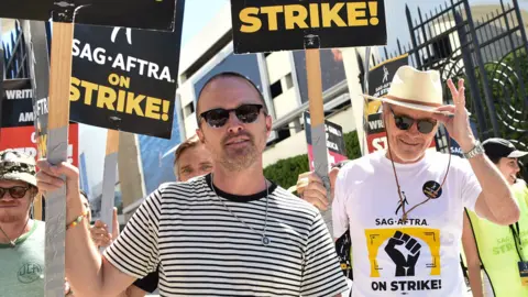 Getty Images US actors Bryan Cranston and Aaron Paul join the Screen Actors Guild (SAG-AFTRA) picket line in front of Sony Pictures Entertainment Studios in Culver City, California, on August 29, 2023