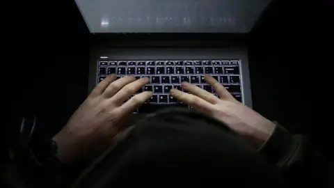 Getty Images Hands on a computer keyboard