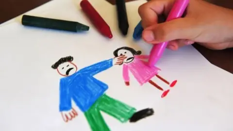 Getty Images Child drawing an image of domestic abuse