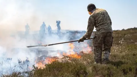 PA The military and firefighters tackle a wildfire near Saddleworth Moor