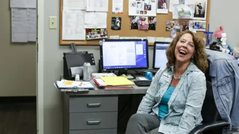 BBC Rhonda Francis at her desk, smiling