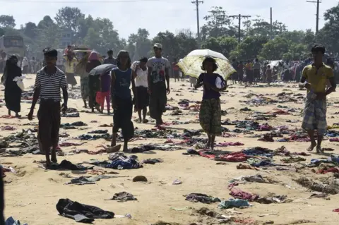 AFP Rohingya Muslim refugees walk past discarded clothing on the ground at the Bhalukali refugee camp near Ukhia, 16 September