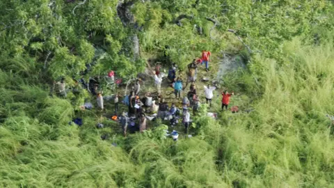 Dyck Advisory Group People waving at a helicopter at IVO Nhica do Rovuma near Palma, Mozambique - March 2021