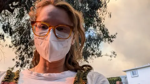 A young women in glasses wearing a mask to protect herself from smoke