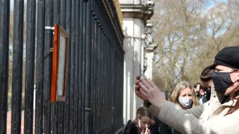 PA Media A member of the public takes a photograph of the Palace notice on a phone on 9 April 2021