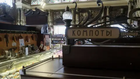 Getty Images MOSCOW, RUSSIA - MARCH 30, 2021: The Yeliseyevsky store in Tverskaya Street. The store was opened by merchant Grigory Yeliseyev in 1901 as Eliseev's Shop and Cellars of Russian and foreign wines. The store marked the 120th anniversary since its opening on February 5, 2021. Signs read "Kompots" (L) and "Nectars."