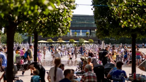 PA Media Children play in fountains in Granary Square, London