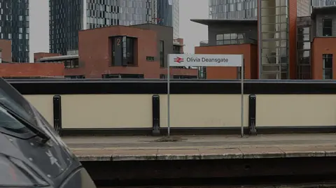 Olivia Deansgate sign on platform at Deansgate Station.