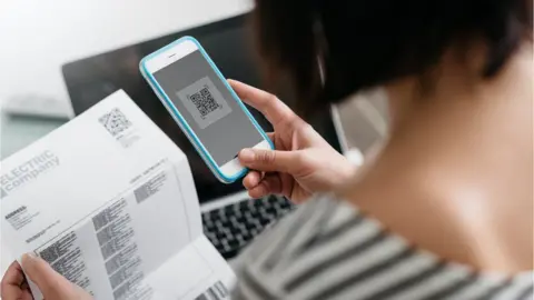 Getty Images Electricity bill/ smartphone