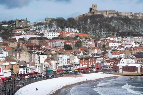 AFP Snow covers the beach in the sea side resort of Scarborough in North Yorkshire