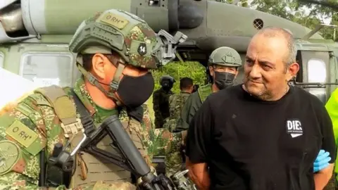 Reuters Dairo Antonio Usuga David, alias "Otoniel", top leader of the Gulf clan, is escorted by Colombian military after being captured, in Turbo, Colombia October 23, 2021