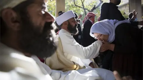 EPA A woman kisses the hand of the new Baba Sheikh