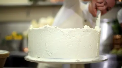 PA Claire Ptak puts finishes touches to the wedding cake