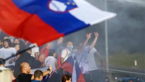 Reuters Protesters get hit by a water cannon during a protest against the coronavirus disease (COVID-19) restrictions from the government, in Ljubljana, Slovenia, September 29, 2021