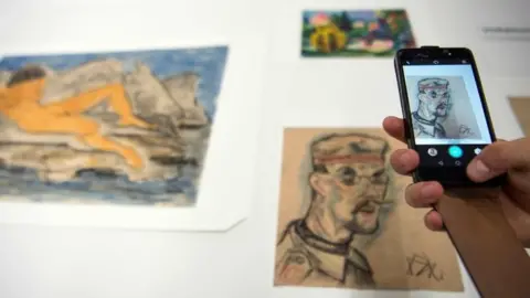 AFP A journalist takes a picture with a mobile phone of the art pieces coming from the estate of German collector Cornelius Gurlitt during a press preview of the first masterpieces of the estate of Gurlitt at the Museum of Fine Arts Bern (07 July 2017)