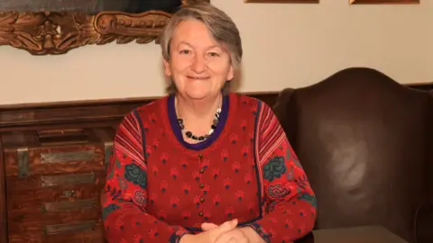 Maria Fowler Sue Daish sat by a table