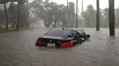 Getty Images Partially submerged car in flood water