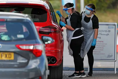 Getty Images A medical worker takes a swab to test for Coronavirus, Chessington, May 2020