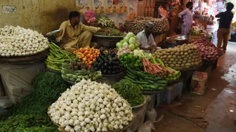Getty Images Pakistani vendors wait for customers at a market in Karachi on October 9, 2018.
