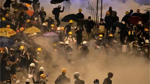 AFP Protesters run away from tear gas