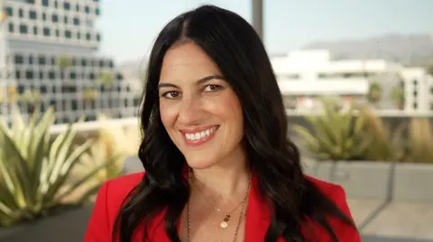 Carolina García smiles on a building rooftop