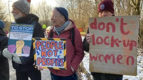 Three protestors holding banners outside Derwentside Immigration Removal Centre