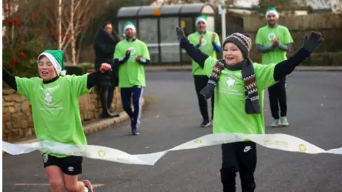 Katy Higginson  Freddie finishing his last Christmas Day run in 2020, with Hughie cheering him on