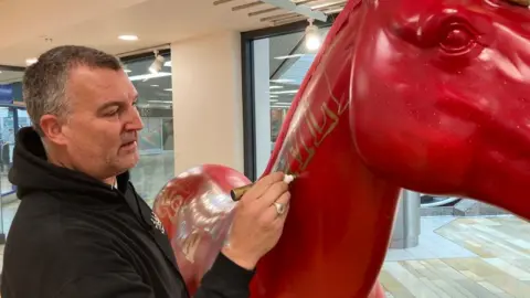 BBC Artist Inkie painting one of his two unicorns