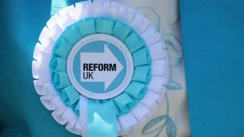 EPA Reform UK rosette pinned to a campaigner 