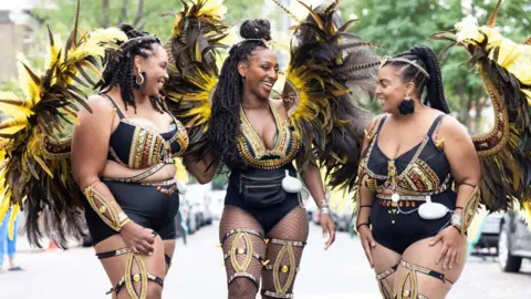 PA Media Singer Alexandra Burke joined The Utopia Band who wore breast pumps under their black and gold costumes