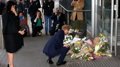 PA Prince Harry lays flowers outside the commission