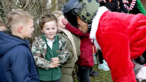 Royal Navy observer Lt Aren Tingle greets children at Landewednack Primary School in The Lizard