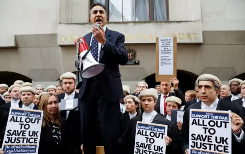 Reuters Criminal Bar Association chair Jo Sidhu with a megaphone surrounded by barristers outside the Old Bailey