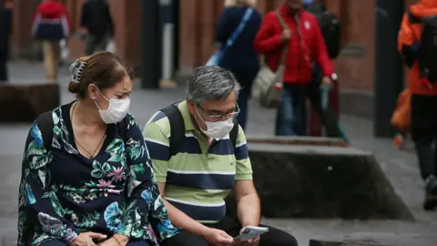 Getty Images A man and a woman wear face masks in the Chinatown district of Sydney