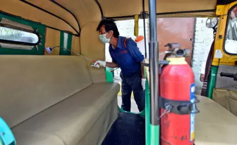 Getty Images DTC cleaning staff chemically disinfect and sanitize auto rickshaw as a precautionary measure in view of coronavirus concerns, at Vasant Vihar Depot on March 17, 2020 in New Delhi, India.