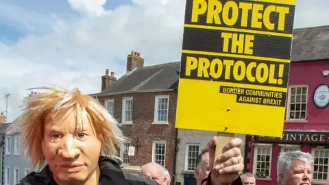 Getty Images Protester in a mask supporting the protocol on 16 May 2022 in Hillsborough
