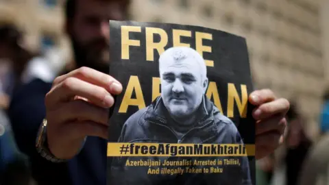 Reuters A man attends a rally in Tbilisi, Georgia on 31 May 2017 to support Azeri Journalist Afgan Mukhtarli, who was abducted in Tbilisi on 29 May and now is in detention in Baku, Azerbaijan