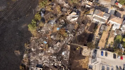 PA Media Aerial photo of the burnt-out sites where the homes were