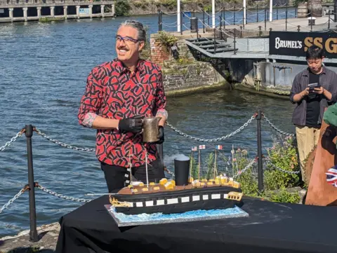 Giuseppe Dell'Anno in front of the SS Great Britain cake replica