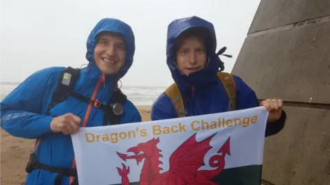 @DragonChallenge Mike and Matt standing in the rain holding a flag