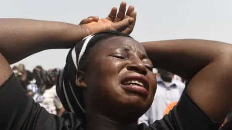 AFP A woman cries during a funeral service
