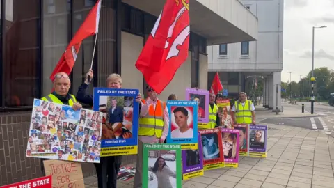 John Fairhall/BBC Protesters outside Chelmsford coroner's court