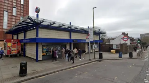 StreetView image of the entrance to Colindale Tube station, with people walking past